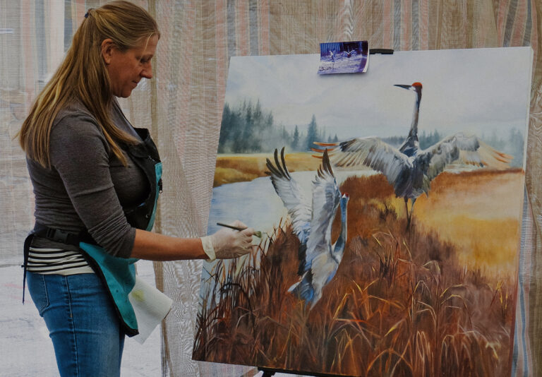A woman is painting on a canvas.