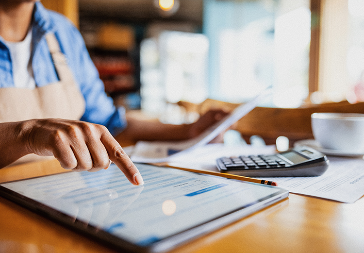 A woman uses the touchscreen on a tablet.